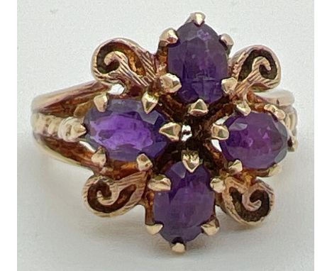 A vintage 9ct gold dress ring set with 4 oval cut amethysts in a floral design setting. Amethyst set between panels of gold w