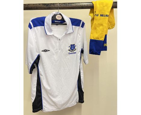 An Everton FC white football shirt with zip collar fastening, size M. Together with a pair of yellow &amp; blue Everton footb