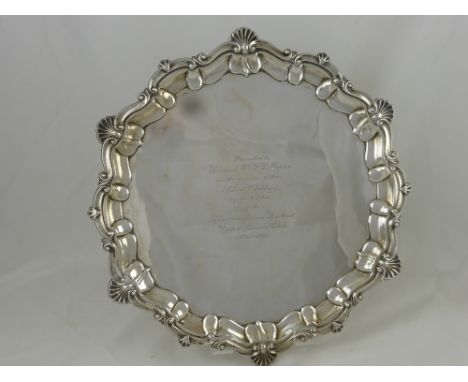 A Silver Presentation Salver, having a shell and laurel edge, on ball and claw feet, inscription reads "Presented to Dr and M