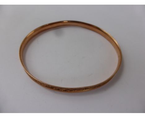 A Lady's 9ct Rose Gold Bangle, engraved with flowers, approx 10 gms.