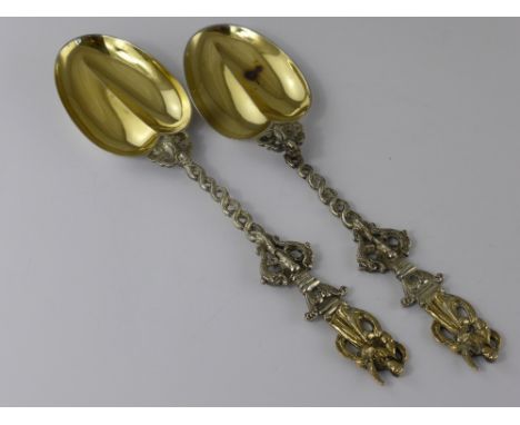 A Pair of Victorian Apostle Serving Spoons, the heart form spoons having dolphin formed twisted stem and apostle finial, Lond