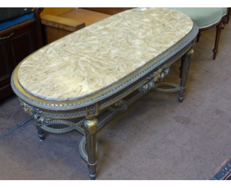 A Louis XIV Style Marble and Gilded Coffee Table, the oval ended table having ribbon border with laurel central frieze, the l