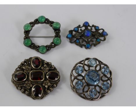 A Miscellaneous Collection of Silver Brooches, including blue glass, jade, garnet and silver metal lue/green stone. (4)