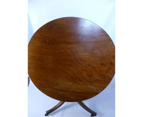 An Antique Mahogany Tilt Top Dining Table, on tripod base with brass castors.