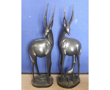 A Pair of Ebonised Carvings of Gazelle, one feeding a calf, 94 cms high. (waf). together with An African Gourd (possibly a ca