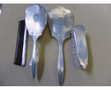 A Solid Silver Dressing Table Set, comprising hand mirror, clothes brush, hair brush and comb, Birmingham hallmark, mm Broadw