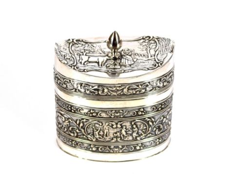 An ornate Dutch silver tea caddy, of elliptical shape, the hinged lid surmounted by a pineapple shaped finial, raised foliate