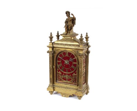 A 19th Century French brass cased musical mantel clock, surmounted by a seated Romanesque figure and flanked by flambe finial