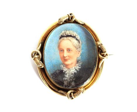 A 12 carat gold oval portrait brooch, depicting a lady with lace headdress and collar, the frame decorated with serpents with