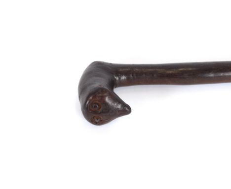An unusual 19th Century African carved walking stick, having flattened twin eyed head terminal