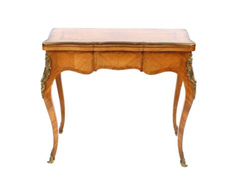 A 19th Century French walnut and kingwood cross-banded serpentine shaped card table, having ormolu mounts, the fold-over top 