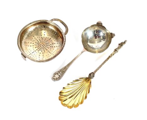 A silver tea strainer, by Edwin Viner of Sheffield 1935; a fancy late Victorian silver and gilded serving spoon having fluted