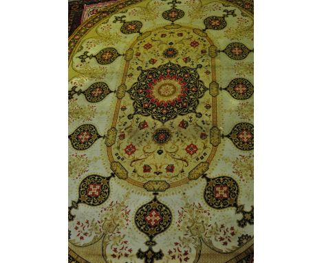 A Portuguese Donegal style gold ground oval carpet woven with a central lobed floral medallion, 350 x 246cm