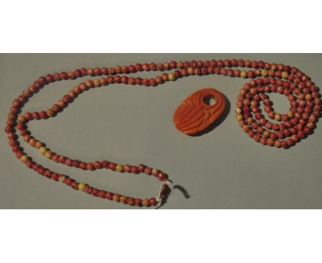 An unusual Art Deco carved coral pendant together with a coral bead necklace