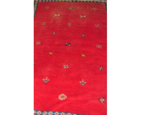 A Gabbeh red ground small carpet with geometric field within a narrow conforming border, 310 x 205cm