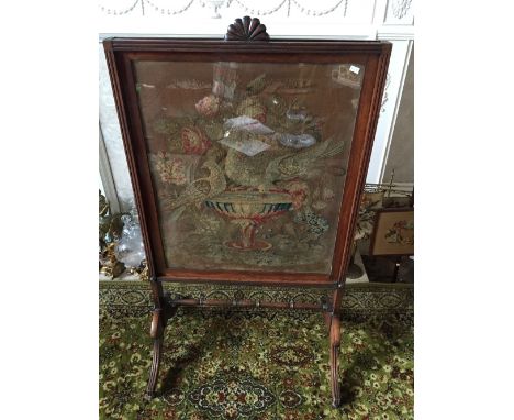 Nineteenth century rosewood firescreen with framed cross stitch panel a/f, panel raises. 95x56cms.