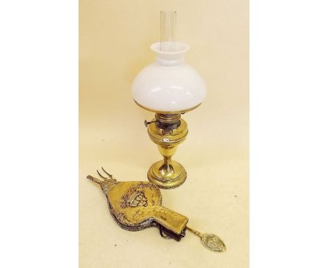 A brass oil lamp with opaque glass shade, a pair of bellows and a toasting fork