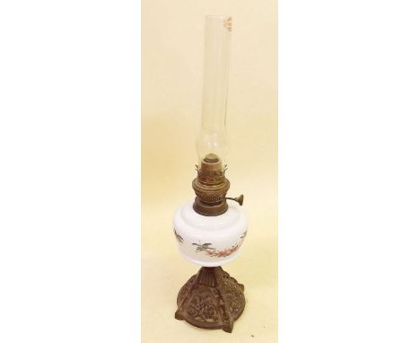 A Victorian cast iron oil lamp with floral painted reservoir