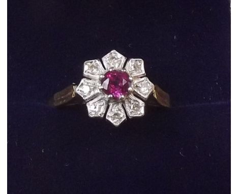 An 18 carat gold ruby and diamond cluster ring size O