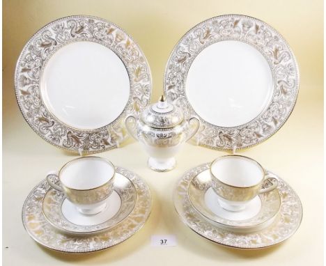 A Wedgwood Gold Florentine part tea service comprising:- six teacups and saucers, two cake plates, two side plates and a lidd
