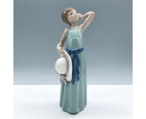 Glossy figure in long green dress with blue sash holding her hat in one hand and a shell to her ear with the other. Lladro ba