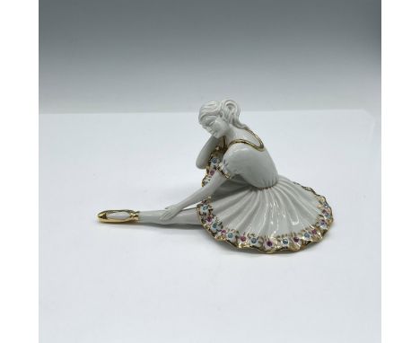 Figure in resting pose with leg extended. Dress is adorned with multicolor Swarovski crystals along with gilt accents on the 