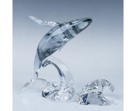 A magnificent whale leaps gracefully over a wave, showcasing its belly in an upside down position, accompanied by a plaque sh