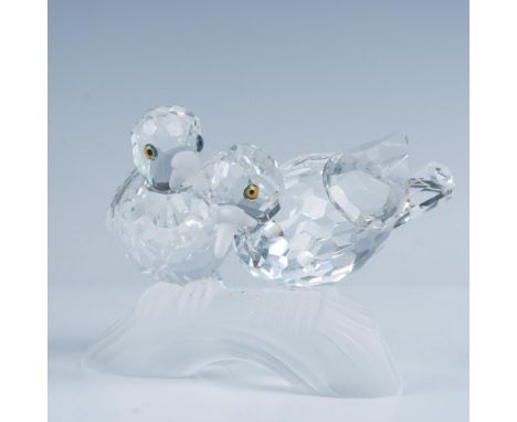 A charming pair of turtledoves nestled together on a frosted branch, cuddling lovingly and adorned with amber crystal eyes. S