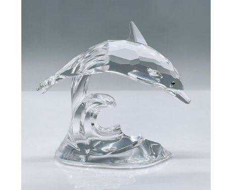 Features a graceful dolphin with a sleek body in faceted clear crystal and Sahara crystal eyes jumping through an ocean wave.