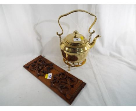 A good quality brass kettle on stand and a sliding book trough (2)