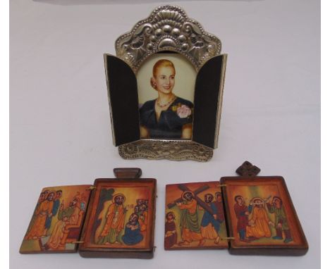 A framed portrait of Eva Peron and two painted wooden icons