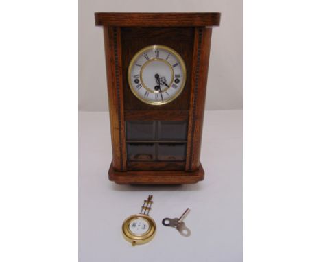 An oak cased rectangular mantle clock, white enamel dial, Roman numerals, glazed front to include key and pendulum, 37.5 x 22