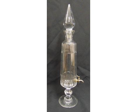 A glass decanter tapering cylindrical with drop stopper and metal spigot on raised circular base, 55cm (h)