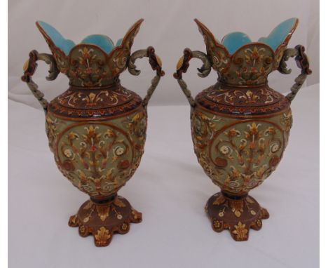 A pair of continental ceramic two handled vases decorated throughout with flowers and leaves on raised circular bases, 40cm (