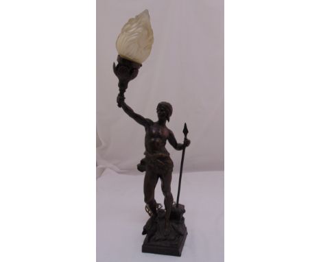 A spelter lamp stand in the form of a warrior holding a spear and supporting a frosted glass flame shade, 69cm (h)