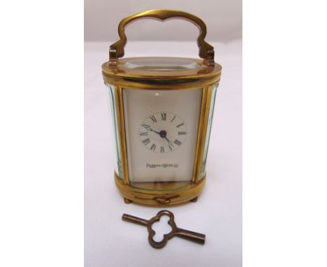 Mappin and Webb miniature brass carriage clock of oval form with white enamel dial, Roman numerals, to include key, 8cm (h)