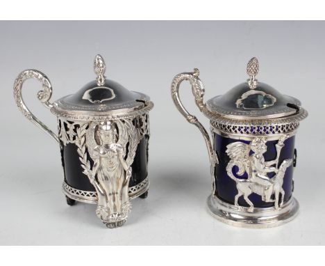 Two early 19th century French silver mustards, each of cylindrical form with hinged lid and pine cone finial, fitted with a b