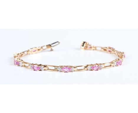 A gold, pink sapphire and diamond bracelet, claw set with ten oval cut pink sapphires, each mounted between two circular cut 