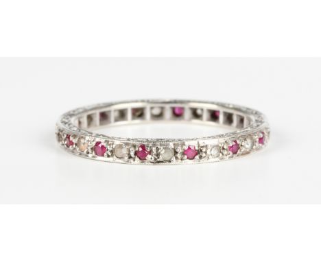 A white gold, ruby and colourless gem set eternity ring, mounted with circular cut rubies alternating with circular cut colou