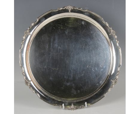 A George V silver circular salver with cast stylized flower and scrolling leaf rim, Sheffield 1935 by Cooper Brothers &amp; S
