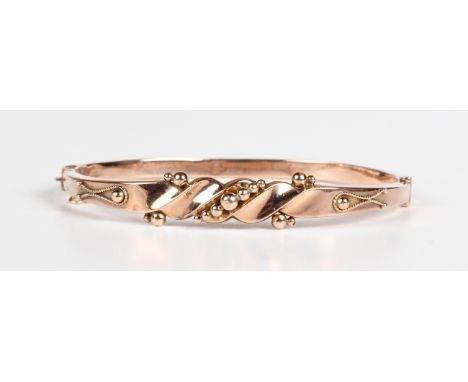 A 9ct gold oval hinged bangle, the front with applied bead and wirework decoration in a slanting design, Chester 1923, weight