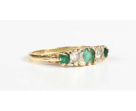 A gold, emerald and diamond ring, mounted with three circular cut emeralds alternating with two circular cut diamonds, weight