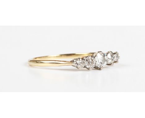 A gold and diamond five stone ring, claw set with a row of cushion cut diamonds graduating in size to the centre stone, unmar