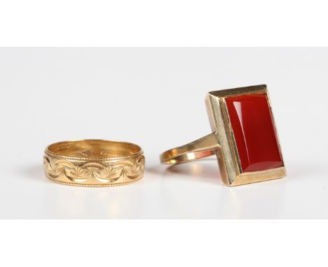 An 18ct gold decorated wedding ring, London 1996, weight 2.7g, ring size approx K, and a gold panel shaped ring, collet set w