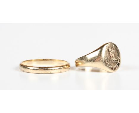 A 9ct gold oval signet ring, crest and motto engraved, London 1990, ring size approx H1/2, and a 9ct gold wedding ring, Birmi