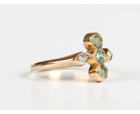 A gold, demantoid garnet and diamond ring, early 20th century, collet set with three circular cut demantoid garnets between d