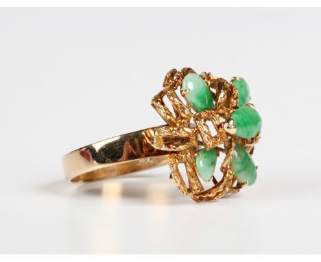 An Asian gold and jade ring, mounted with five pear shaped jades in an abstract design, detailed '14K', weight 6g, ring size 