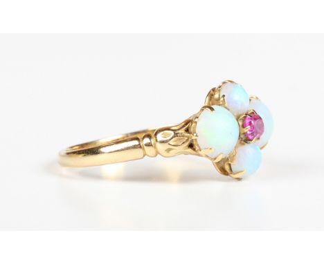 An Edwardian gold, opal and ruby ring, claw set with the cushion cut ruby within a surround of four circular cabochon opals, 