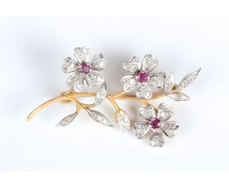 A gold, ruby and diamond brooch, designed as a floral and foliate spray, mounted with circular cut rubies and diamonds, unmar