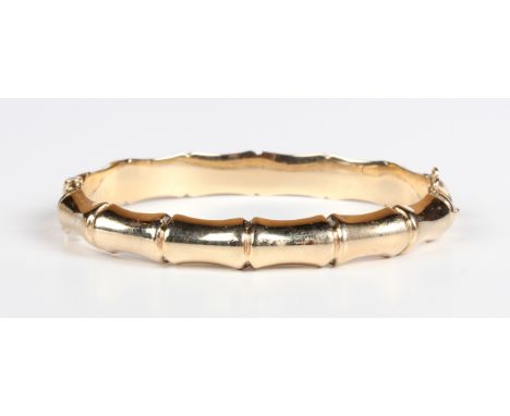 A 9ct gold oval hinged bangle in a bamboo design, on a snap clasp, Chester 1959, weight 11.3g, inside width 6cm.Buyer’s Premi
